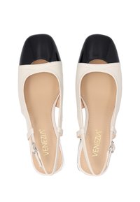 Bezdotykové slingback boty v béžové a černé lakované kůži s otevřenými stranami, kulatou špičkou a kotníkovým páskem. S lesklou černou špičkou a hladkou texturou.