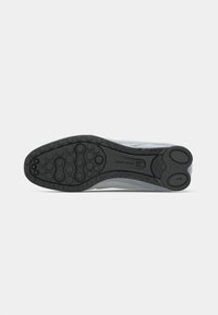 Must musta spordijalatsi tald ringikujuliste mustritega ja "NIKE SWOOSH" bränding hallil taustal.
