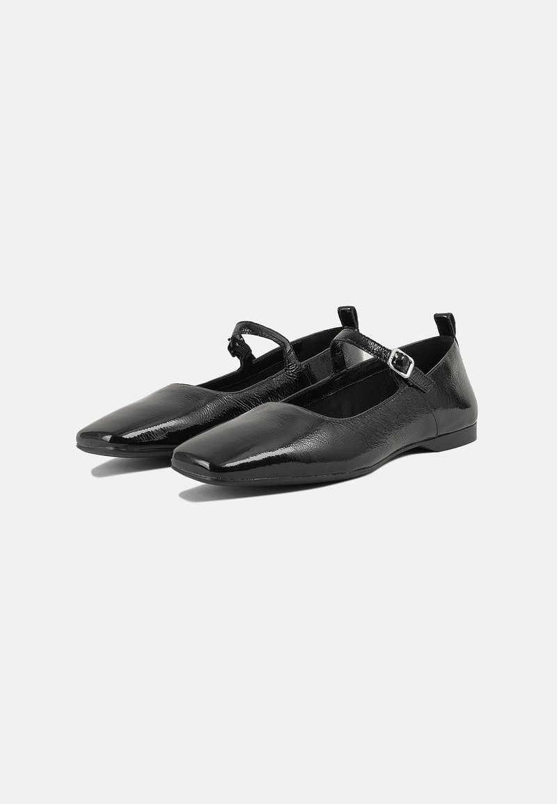 Ballet flats en cuir noir avec un bout carré, une sangle de cheville et une finition texturée, présentant des zones lisses et une semelle discrète.