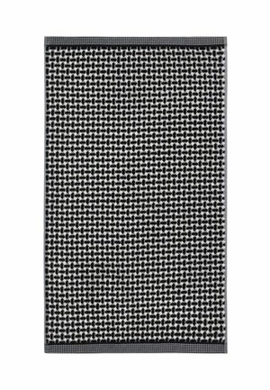 Black and white woven rug with a repeating geometric pattern and narrow dark borders at top and bottom edges.