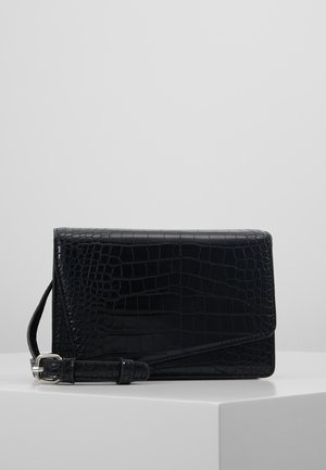 Sort taske i kunstlæder med krokodilleprint og flapdesign, udstyret med en aftagelig skulderrem og en glat, blank tekstur.