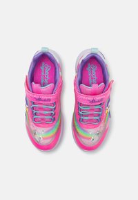 Des chaussures de sport roses avec un dessus pailleté, des accents arc-en-ciel et une sangle velcro. Marque sur le côté et semelle texturée.