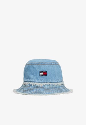 Chapeau seau en denim bleu clair, avec un bord effiloché. Une patch de marque en rouge, blanc et bleu sur le devant ajoute un détail.
