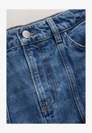 Blugi din denim cu spălare albastră estompată, design cu cinci buzunare și cusături contrastante portocalii, prevăzuți cu un nasture metalic în talie.