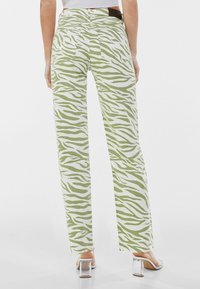 Gröna och vita zebra-randiga högmidjade jeans med rak benvidd, med bakfickor och fransig nederkant.