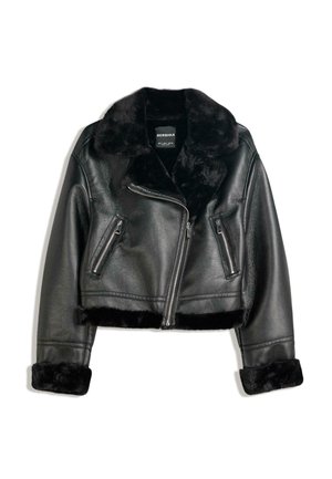 Veste en simili cuir noire avec col, poignets et ourlet en fausse fourrure douce, dotée d'une fermeture éclair asymétrique à l'avant et de deux poches zippées.