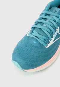 Ελαφρύ παπούτσι για τρέξιμο σε τυρκουάζ δίχτυ με λευκές λεπτομέρειες. Διαθέτει επάνω μ έρος με μοτίβο, επενδεδυμένη γλώσσα και ροζ περίγραμμα στη σόλα.