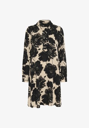 Svart klänning med blommönster på en beige bakgrund, utrustad med krage, placket med tre knappar och lång ärm med manschettdetaljer.