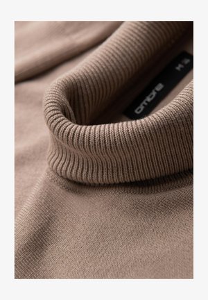 Maglione marrone lavorato a maglia con un colletto alto a coste. Texture liscia, cuciture minime e etichetta visibile, che trasmette un design semplice.