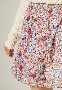 Falda floral con un patrón multicolor en tonos de rosa, azul y púrpura, cintura elástica y tejido ligero y suave.