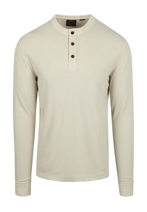 Camisa de manga larga color beige claro, hecha de algodón acanalado, con un escote redondo, tapeta con cuatro botones y puños ajustados.
