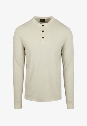 Camisa de manga larga color beige claro, hecha de algodón acanalado, con un escote redondo, tapeta con cuatro botones y puños ajustados.