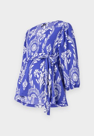 Mėlynas apykaklės viršus su baltais gėlėmis, 3/4 ilgio rankovėmis, juosmens raišteliu, tekstūruota medžiaga ir V formos iškirpte.