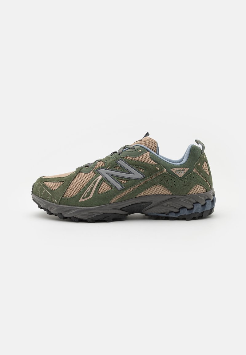 Chaussure de trail running en vert olive et beige avec une semelle robuste et un design à lacets, arborant un logo "N" bien visible sur le côté.