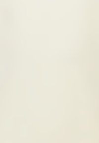 Vase en céramique blanc cassé avec une surface lisse et mate, de forme évasée, présentant une texture subtile sans motifs ni accents visibles.