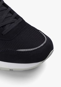 Tenisi de culoare bleumarin cu un superior din plasă texturată, accente din suede, detalii reflectorizante și o talpă din cauciuc alb pentru un contrast suplimentar.