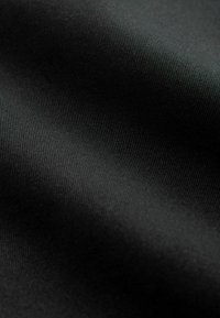 Melna auduma ar gludu tekstūru un vieglu ribu rakstu, kas izceļ mīkstu krītošumu un vienmērīgu krāsojumu visā virsmā.