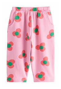 Pantaloni della tuta rosa con cintura elastica, caratterizzati da un motivo di fiori rossi con centro verde e tasche laterali. Realizzati in misto cotone.