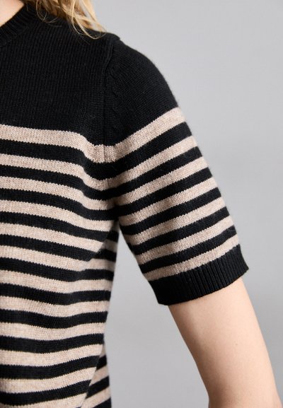 Lyöty yhteistyö suutarin lyhythihainen villapaita, jossa on musta ja beige vaakasuora raidoitus, ribbireunalla varustettu pyöreä kaula-aukko ja istuva muoto.