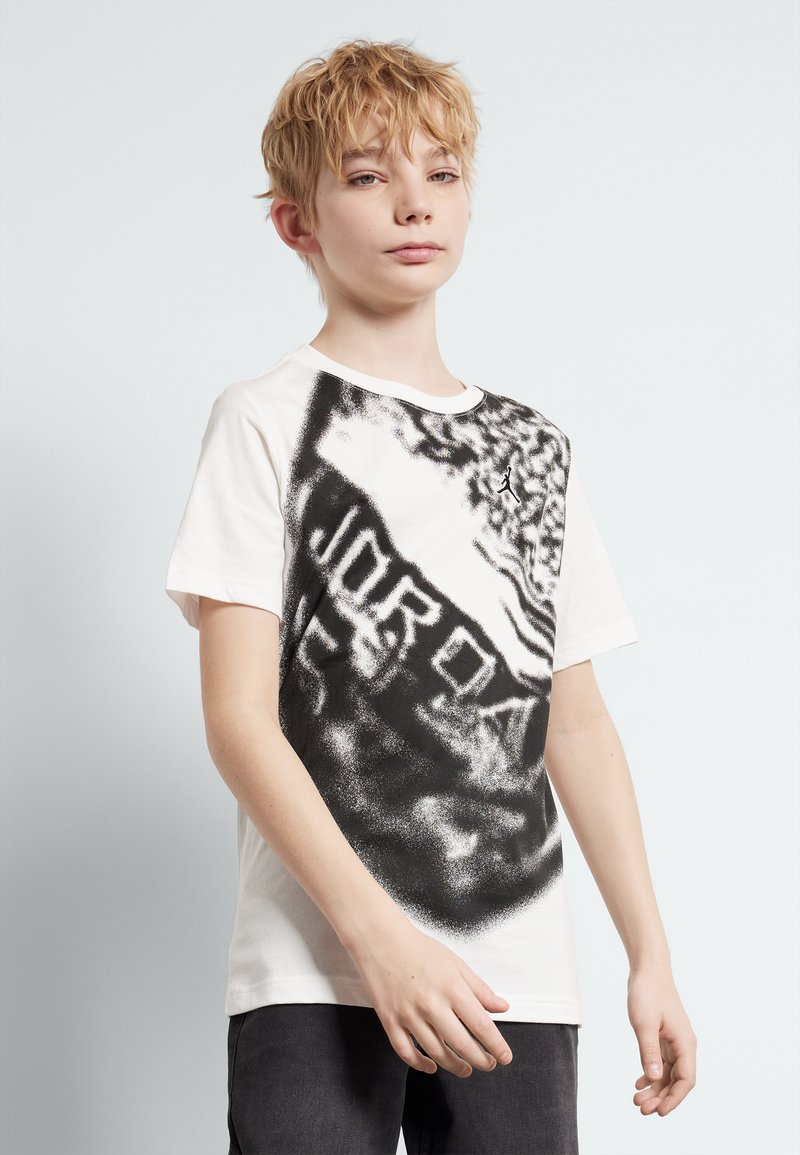 White T-shirt featuring a black graphic print, including the word "JORDAN," with short sleeves and a round neckline.