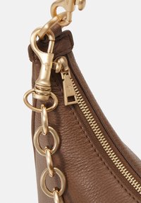 Borsa a mano in pelle marrone con zip dorata, grandi dettagli in catena dorata e chiusura a moschettone. La superficie testurizzata aggiunge profondità.