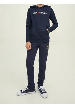 Mørkeblå hættetrøje med "JACK JONES" logo, frontlomme. Koordinerende mørkeblå sweatpants med et logo-patch, parret med mørkeblå sneakers og hvide snørebånd.