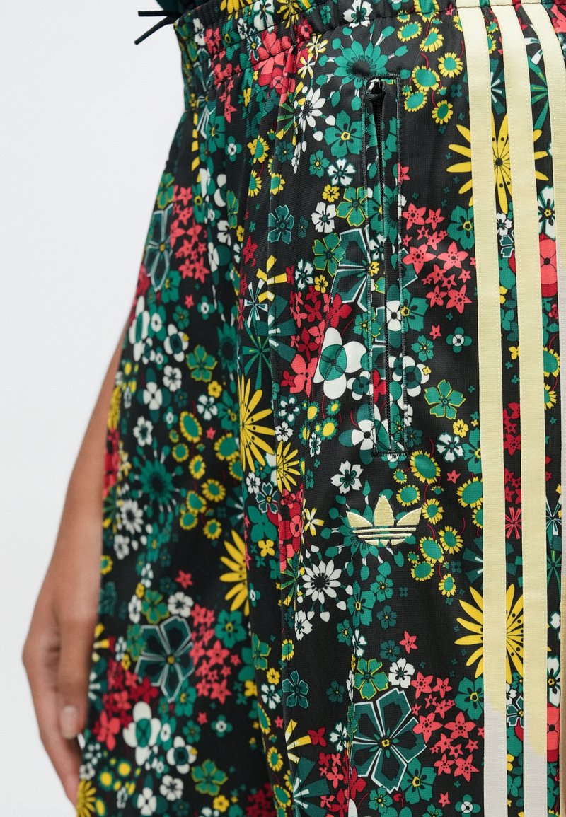 Floral-patterned skirt in black with green, yellow, red, and white flowers; features three yellow stripes and a side pocket.