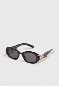 Μαύρα οβάλ γυαλιά ηλίου με σκούρους φακούς, γυαλιστερό φινίρισμα, χρυσές διακοσμητικές λεπτομέρειες στα μπράτσα και τη σήμανση "ANNA FIELD".