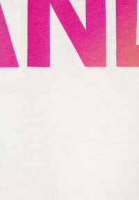 Weißer Stoff mit großen, gradienten, pinken Buchstaben. Die Textur ist glatt und baumwollähnlich und zeigt ein mutiges, modernes Design.