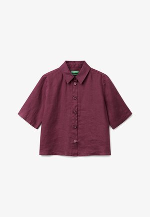 Camicia a maniche corte, con bottoni, di un profondo colore viola, con collare classico, vestibilità sagomata e texture del tessuto liscia su sfondo bianco.