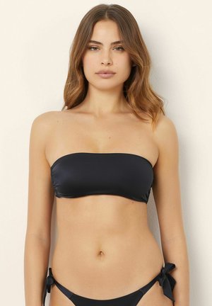 Czarny bikini top bandeau o gładkiej fakturze i minimalistycznym wzornictwie. Posiada fason bez ramiączek i zestawiony jest z majtkami związanymi po bokach.