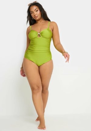 Maillot de bain une pièce vert avec un décolleté en cœur, détail en trou de serrure et un accent circulaire au niveau de la poitrine. Fines bretelles et texture lisse.