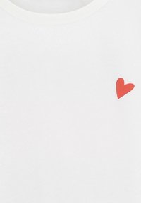 Witte katoenen t-shirt met een rode hartafbeelding aan de onderzijde. Rond decolleté met een eenvoudige afwerking. Zachte textuur.