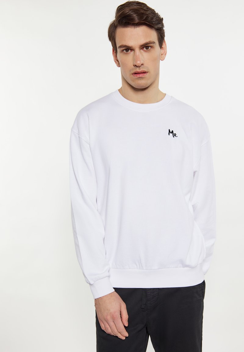 Sweatshirt alb cu guler rotund și umeri lăsați. Prezentă un mic logo negru "Mr." pe piept și manșete ribbate la mâneci și la baza.