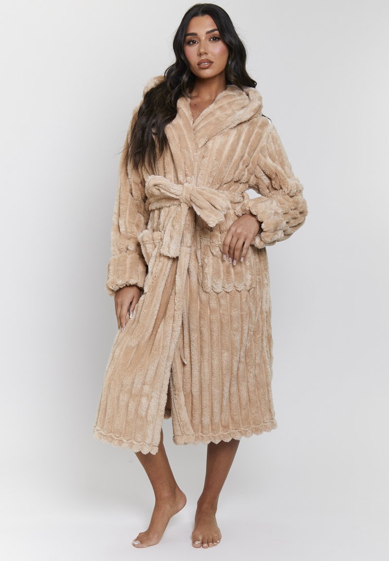 Accappatoio plush beige con colletto a scialle, cintura da legare e texture a coste. Presenta un orlo scallop e maniche lunghe per il comfort.