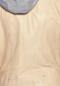 Beige läderjacka med grå huva, med vertikala sömdetaljer och en bakficka med knäppningsdetalj.