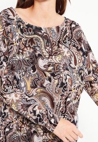 Koszula z długim rękawem z wzorem paisley w odcieniach brązu, kremu i złota, z okrągłym dekoltem i miękkim, teksturowanym materiałem.