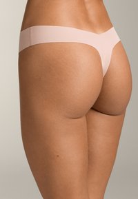 Rosa String-Tanga-Unterwäsche aus glattem, elastischem Material. Verfügt über ein minimalistisches Design mit einem breiten Bund und einer nahtlosen Verarbeitung.