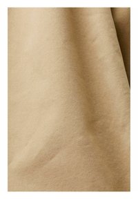 Tessuto beige, morbido, con una texture liscia, caratterizzato da un design semplice e non decorato. Il materiale presenta leggere pieghe e avvallamenti.