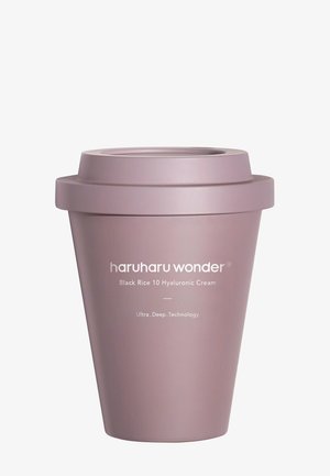 Lila zylindrischer Behälter mit strukturierter Oberfläche; verfügt über einen Deckel an der Oberseite. Das Etikett enthält den Produktnamen und eine Beschreibung in weißem Text.