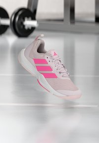 Lys rosa sportssko med rosa detaljer og teksturert mesh-oppbygging. Har det tre stripe-logo, polstret krage og hvit såle.