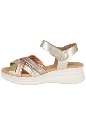 Sandalia metálica para mujer con múltiples tiras, plantilla acolchada, correa ajustable en el tobillo y suela blanca gruesa, mostrada en perfil lateral.