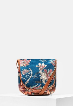 Sac bandoulière bleu avec motifs floraux roses et oranges et une sangle réglable marron, placé sur un piédestal blanc.