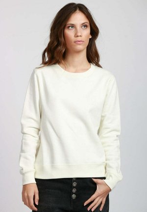 Felpa color crema realizzata in tessuto morbido, con scollo rotondo, maniche lunghe e orlo a coste. Nessun motivo o dettaglio metallico visibile.