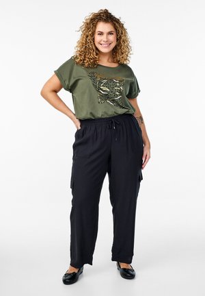 Olive green T-shirt with a leopard print design, paired with black, loose-fitting cargo pants featuring elastic waistband and pockets.