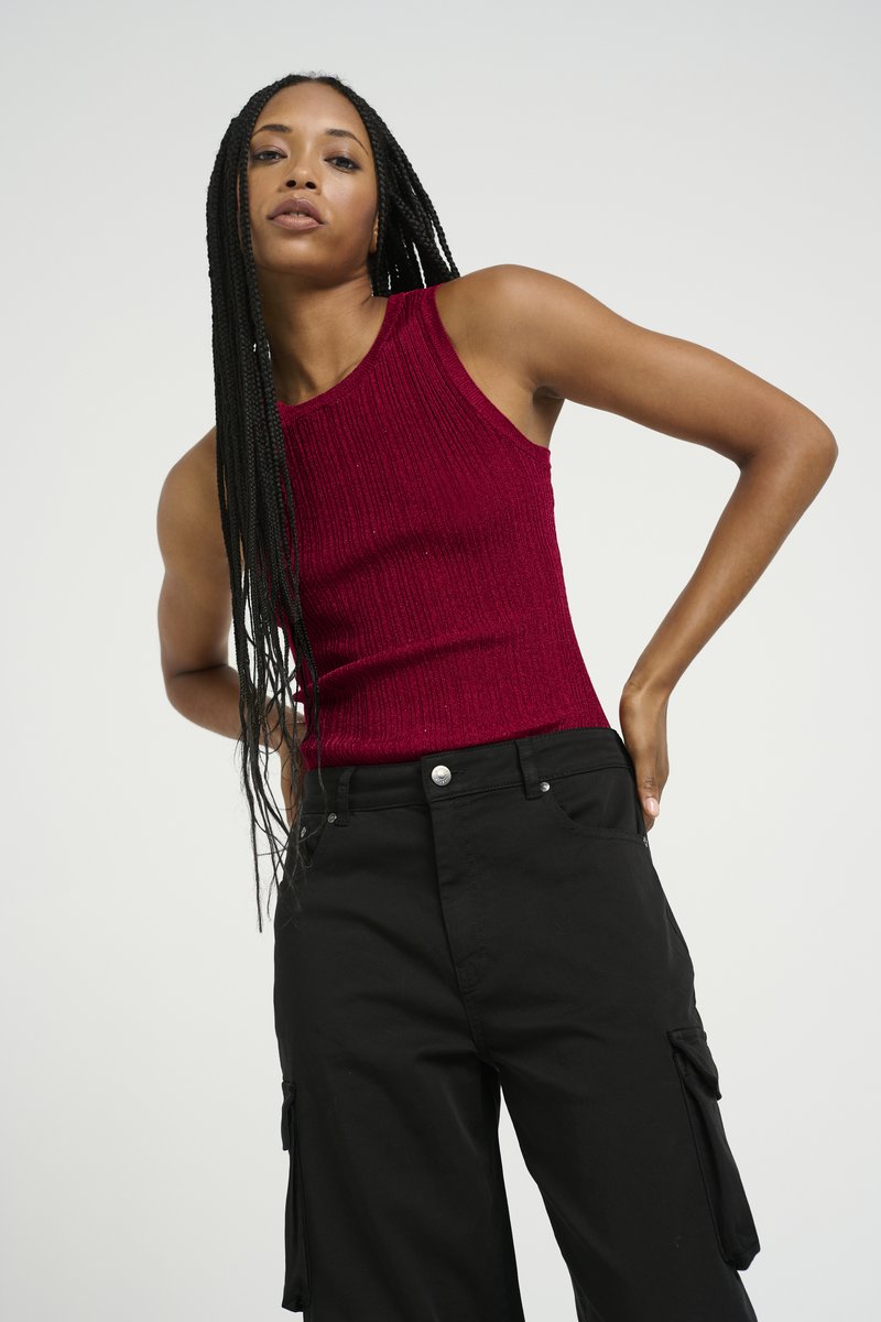 Burgundy ribbed tank top with a crew neckline, paired with black cargo pants featuring side pockets and a sleek, structured design.