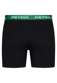 Svarta boxerkalsonger med en grön midjeband som har "PETROL" i vitt, tillverkade av mjukt tyg, som visar en slät textur och en smal passform.
