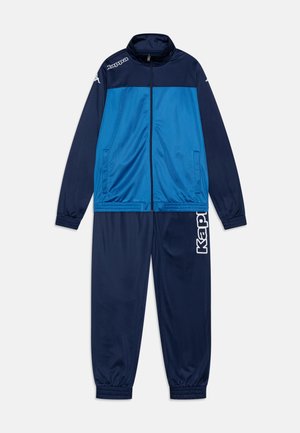 Tuta in tessuto blu e navy, dotato di giacca con zip e colletto alto, polsini elasticizzati e pantaloni con logo Kappa in bianco.