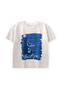Camiseta de algodón blanca con un estampado azul abstracto de un pájaro sobre un pedestal y un elemento circular arriba. Firma debajo del diseño.