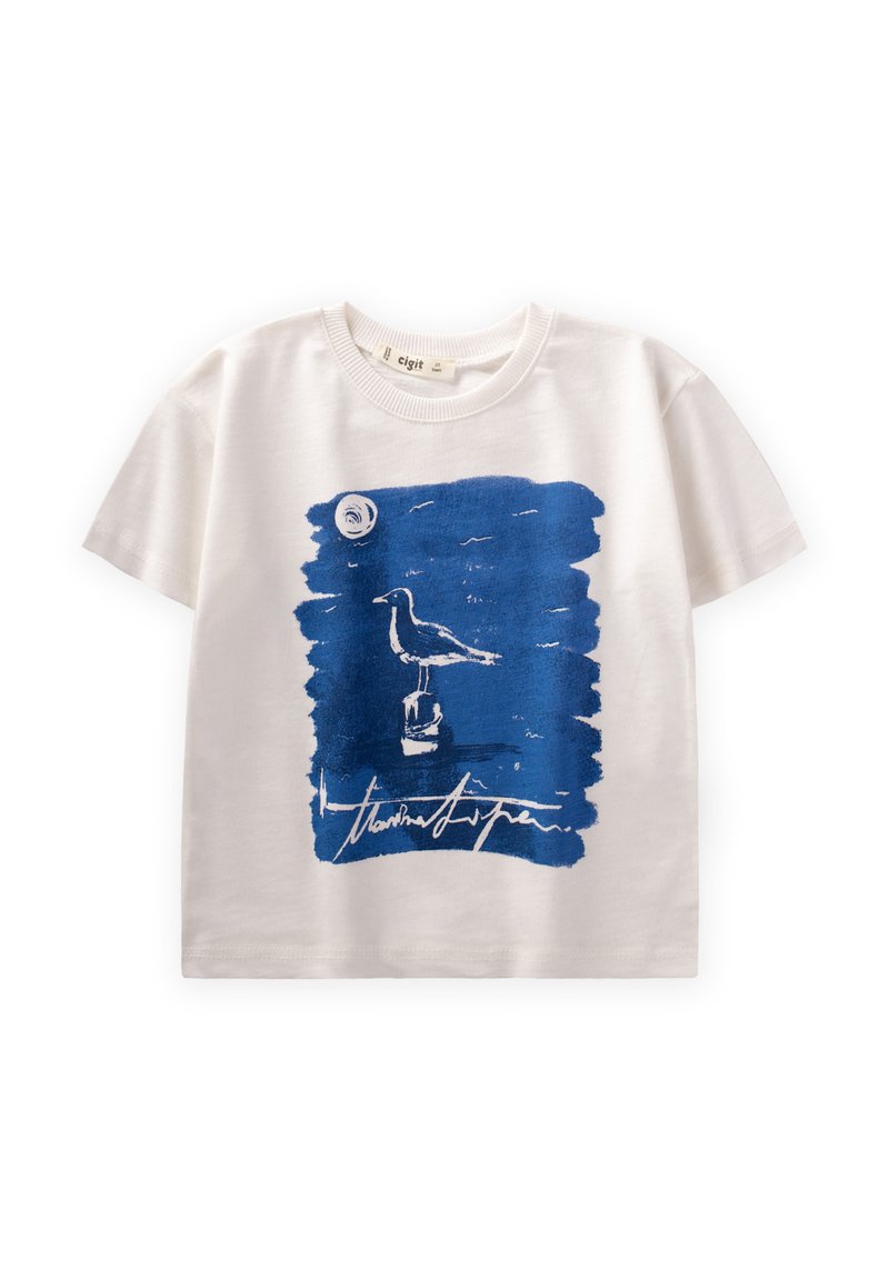 Valge puuvillane t-särk, millel on sinine abstraktne trükk linnust, mis on postamendil, ja ringikujuline element kohal. Allkirja kujunduse all.